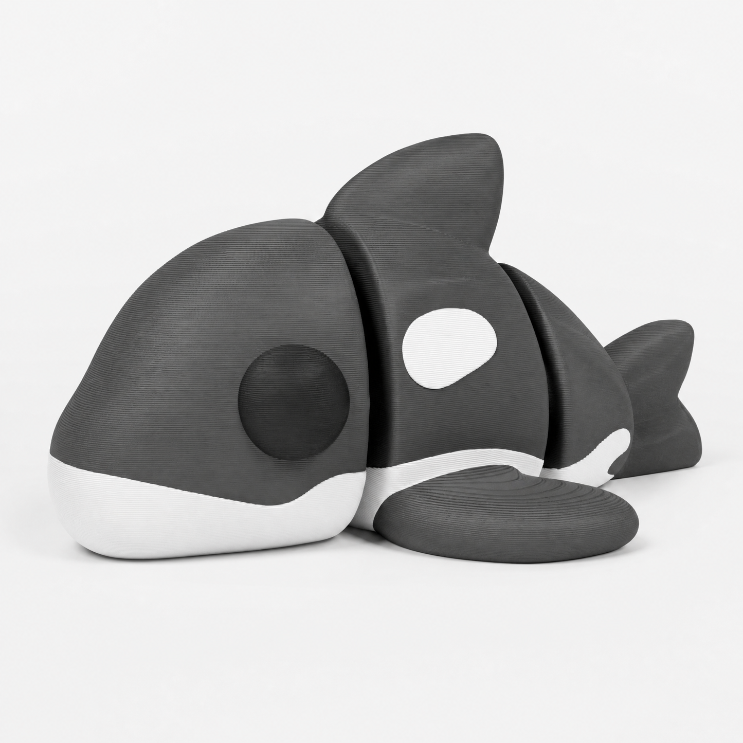 Figura decorativa articulada de orca en blanco, gris y negro sobre fondo perla