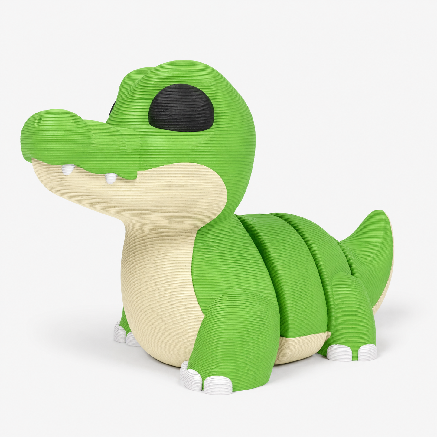 Figura decorativa articulada de cocodrilo en verde, crema, blanco y negro sobre fondo perla