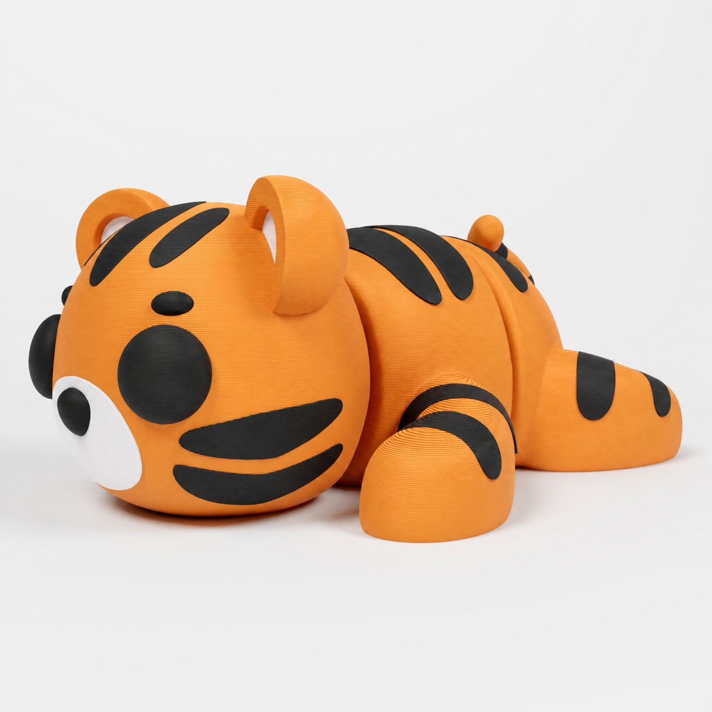 Figura decorativa articulada de tigre en negro, naranja y blanco sobre fondo perla