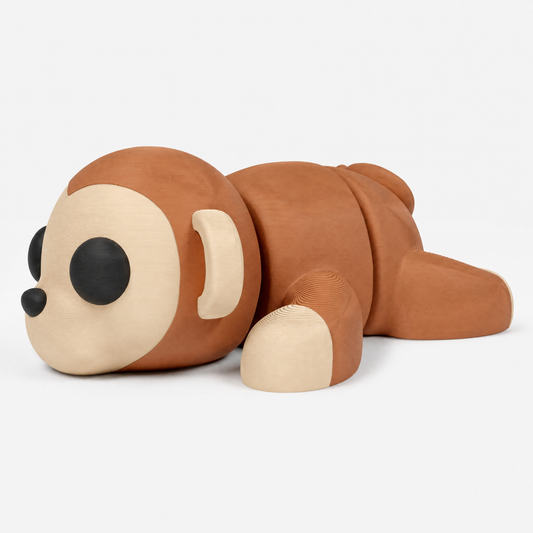 Figura decorativa articulada de mono en marrón, beige y negro sobre fondo perla