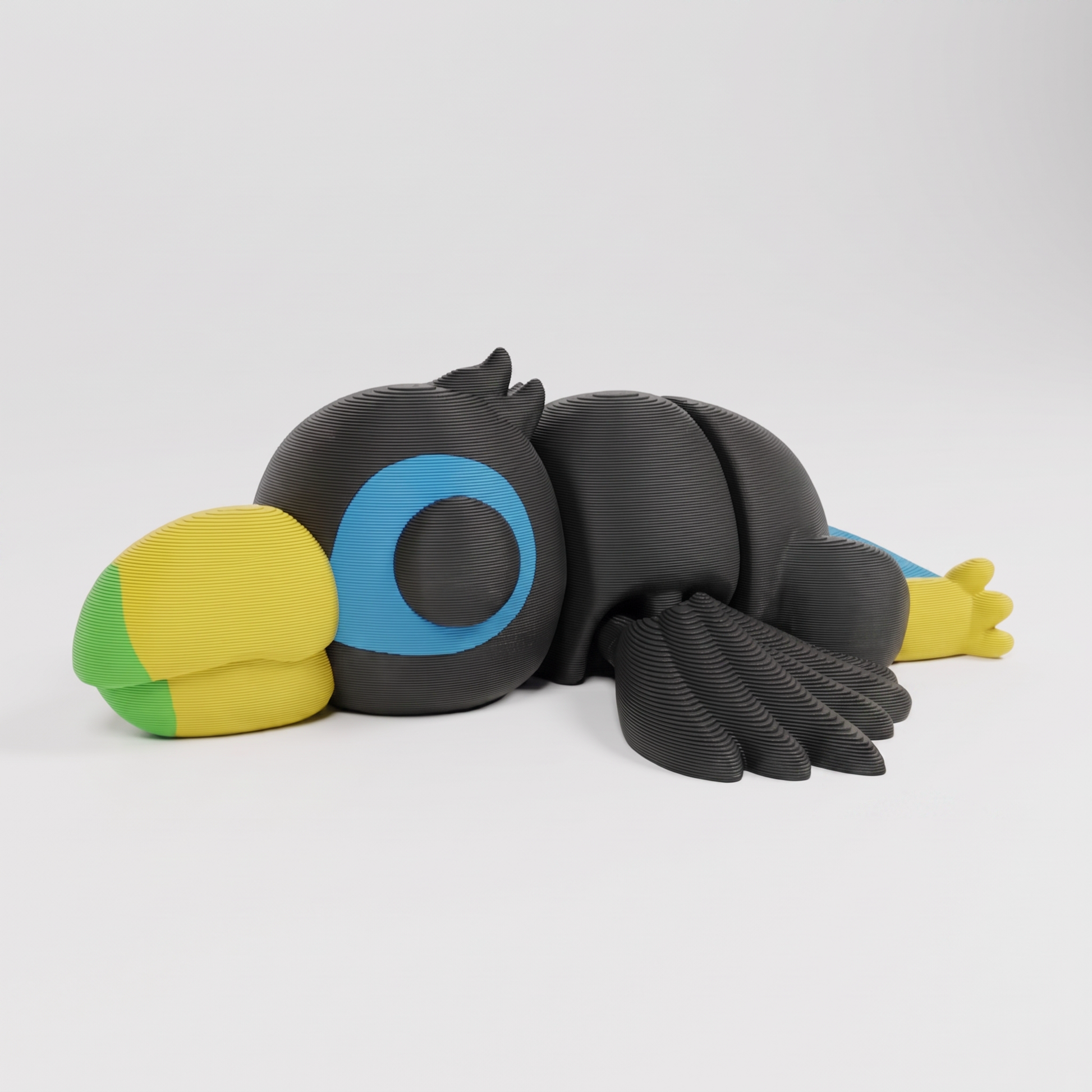 Figura decorativa articulada de tucán en gris oscuro, verde, amarillo y azul sobre fondo perla